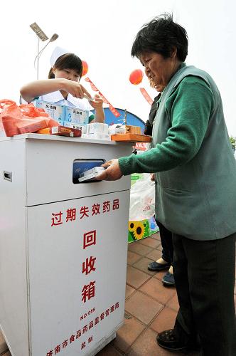 5月18日,一位村民將自己保存的過期藥投入回收箱。新華社記者 朱崢 攝
