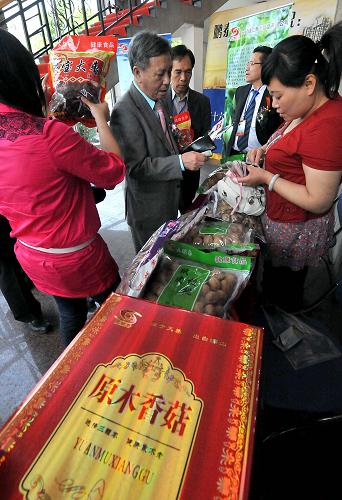 5月19日,在三門峽投資貿(mào)易洽談會上,客商在一個林果產(chǎn)品展銷點前了解市場行情。新華社記者 王頌 攝