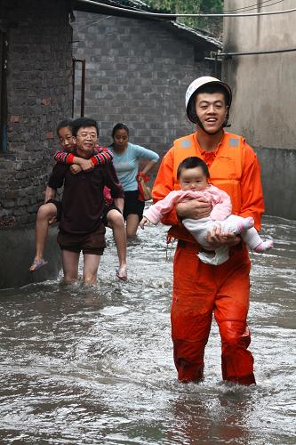 5月21日,消防戰(zhàn)士在江西萍鄉(xiāng)市機(jī)務(wù)段小區(qū)營救被積水圍困的孩子。新華社發(fā)(丁宏 攝)