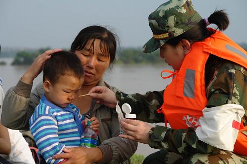 6月22日,武警醫(yī)療隊(duì)員在撫州臨川市唱?jiǎng)P鎮(zhèn)治療一名受傷的兒童。 當(dāng)日,武警江西省總隊(duì)醫(yī)院組織22人的醫(yī)療小分隊(duì)趕到撫州臨川市唱?jiǎng)P鎮(zhèn)撫河決堤口,開(kāi)設(shè)醫(yī)療救治點(diǎn),先后救治100多名轉(zhuǎn)移出來(lái)的被洪水圍困受傷群眾,并免費(fèi)發(fā)放價(jià)值2000多元的藥品。新華社發(fā)(周勇敢 攝)
