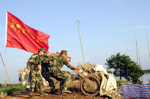 7月20日晨,武警安徽總隊(duì)宣城市支隊(duì)官兵在宣州區(qū)貍橋鎮(zhèn)石馬圩封堵管涌。由于長(zhǎng)江支流水陽(yáng)江水位持續(xù)增高,安徽宣城市宣州區(qū)養(yǎng)賢鄉(xiāng)石馬圩長(zhǎng)時(shí)間受洪水浸泡,出現(xiàn)管涌、滲漏和小面積塌方。7月19日23時(shí)開(kāi)始,武警安徽總隊(duì)宣城市支隊(duì)100名官兵奮戰(zhàn)近11個(gè)小時(shí),截止到20日上午9時(shí)30分,成功封堵1處直徑30余公分的大管涌和6處小管涌,排除了險(xiǎn)情。新華社發(fā)(廖福安 攝)