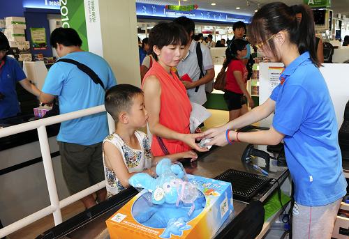 7月21日,游客在世博園特許商品旗艦店購(gòu)買紀(jì)念品。新華社記者 李百順 攝