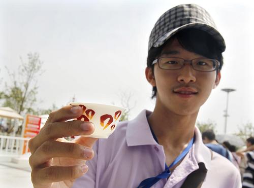 7月21日,臺灣成功高中的范鈞評手持世博會臺灣館贈送的小茶碗說:“這個(gè)帶回去作紀(jì)念,很贊”。彩。新華社記者 劉穎 攝