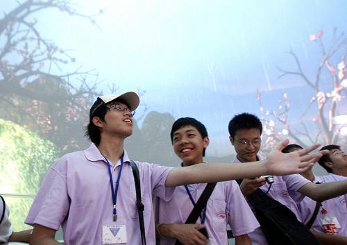 7月21日,滬臺學(xué)生們在臺灣館內(nèi)欣賞可“聞花香、嘗雨趣”的4D電影時(shí),情不自禁伸出手感受落下的雨滴。新華社記者 劉穎 攝