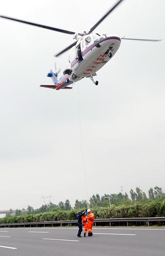 7月22日,交通運(yùn)輸部北海救助飛行隊(duì)S-76直升機(jī)趕到模擬事故現(xiàn)場(chǎng)上空懸停,消防隊(duì)員降到地面實(shí)施救援。新華社記者 徐揚(yáng) 攝