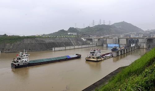 7月22日,貨輪通過(guò)三峽五級(jí)船閘下游引航道準(zhǔn)備進(jìn)閘上行。當(dāng)日,三峽入庫(kù)流量由20日的7萬(wàn)立方米/秒降至4.5萬(wàn)立方米/秒以下。15時(shí),三峽南北兩線船閘徐徐開(kāi)啟,在停航76小時(shí)之后迎來(lái)了首批上、下行船舶。新華社發(fā)(鄭家裕 攝)