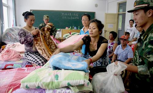 8月4日,丹東邊防支隊(duì)虎山邊防派出所官兵為轉(zhuǎn)移的群眾安排住宿物品。新華社發(fā)(喬俊杰 攝)