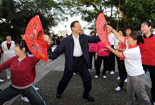 11月14日,國務(wù)院總理溫家寶來到澳門大炮臺(tái)花園,同在這里晨練的市民親切交流,一起練習(xí)太極拳并學(xué)練太極扇。新華社記者 饒愛民 攝
