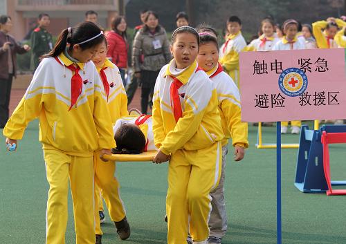 11月29日,在南通第二附屬小學(xué)開展的應(yīng)急聯(lián)合演練活動(dòng)中,一位“傷員”經(jīng)過包扎后被同伴送往“安全地帶”。新華社發(fā)(黃哲 攝)