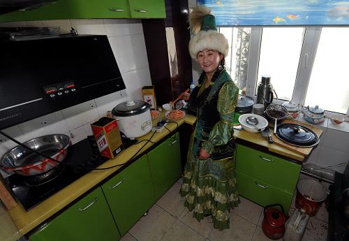 12月17日,一位身穿哈薩克族服飾的牧民在廚房制作美食。新華社記者 趙戈 攝