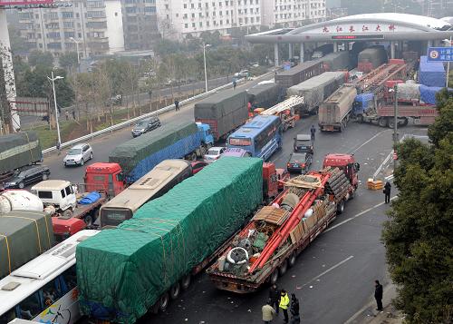 1月27日,在江西九江長(zhǎng)江大橋收費(fèi)站,車輛排隊(duì)等待通行。新華社發(fā)