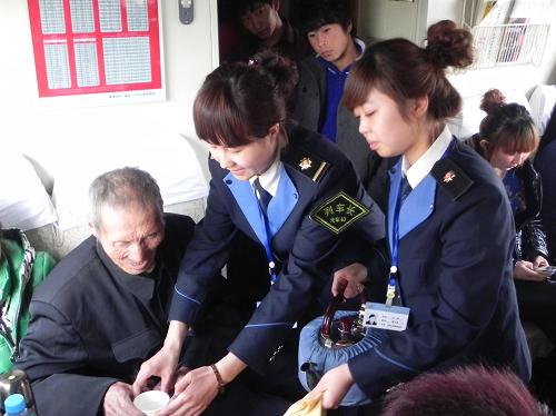 1月27日,K7909次列車乘務(wù)員正在為一位旅客倒水。新華社記者 鄒儉樸 攝