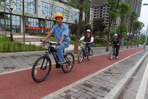5月31日,市民在新建的專用自行車道上騎行。當日,位于重慶市北部新區(qū)大竹林片區(qū)的一條彩色專用自行車道建成,專用自行車道連接大竹林片區(qū)的小區(qū)、學校、工廠、超市和車站,長4.5公里,寬1.5米,路面為橙紅色。車道沿途建有“自行車站”,每個“自行車站”將擺放一定數(shù)量自行車供市民租用騎行。這條專用自行車道屬住建部在重慶市首推的試點工程,以后將在全國大中城市推廣。新華社發(fā)(周會 攝)