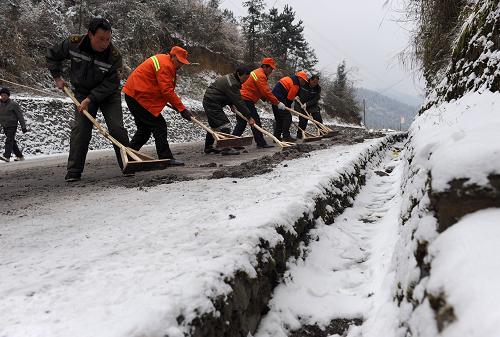 1月4日,湖北恩施土家族苗族自治州宣恩縣路政人員對結(jié)冰的公路路面進行防滑處理。新華社發(fā)(宋文 攝)