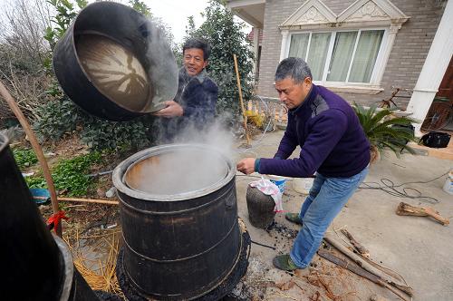 1月5日,長興縣虹星橋鎮(zhèn)白水村60多歲的村民費(fèi)志良(右)正在村里釀酒師傅的幫助下釀造農(nóng)家燒酒,準(zhǔn)備節(jié)日期間招待客人。進(jìn)入農(nóng)歷臘月,兔年春節(jié)也越來越近,浙江省長興縣虹星橋鎮(zhèn)的百姓以傳統(tǒng)多樣的民俗方式準(zhǔn)備迎接農(nóng)歷新年的到來。新華社記者 徐昱 攝