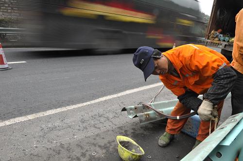 1月9日,一路政人員正在搶修高速公路上被事故車輛撞壞的防護(hù)欄。新華社記者 歐東衢 攝