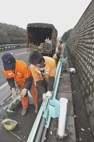 1月9日,路政人員正在搶修高速公路上被事故車輛撞壞的防護(hù)欄。新華社記者 歐東衢 攝
