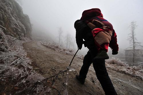 1月10日,在廣西全州縣蕉江瑤族鄉(xiāng)大源村,村民在冰天雪地中艱難前行。新華社記者 黃孝邦 攝