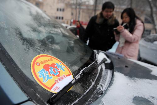 1月13日,一位參與“愛(ài)心車”活動(dòng)的市民(左)正在進(jìn)行登記。近期由烏魯木齊市民間發(fā)起的倡導(dǎo)汽車司機(jī)嚴(yán)寒中免費(fèi)搭載“順風(fēng)客”的做法,受到市民歡迎。加入這些組織的“愛(ài)心車輛”均系彩色絲帶、貼有愛(ài)心車貼。 近日,烏魯木齊遭遇寒流侵襲,許多烏魯木齊私家車主為陌生路人奉獻(xiàn)“順風(fēng)車”;社區(qū)巡邏車、警車紛紛上路搭載需要幫助的乘車者;公交系統(tǒng)全員上陣為乘客提供細(xì)致入微的貼心服務(wù);交警、協(xié)警互相配合疏導(dǎo)擁堵的路況。一系列“暖心行動(dòng)”實(shí)實(shí)在在地化解百姓乘車難、出行難問(wèn)題。 新華社記者 王菲 攝