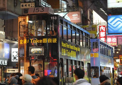兩輛電車從香港銅鑼灣商業(yè)區(qū)經(jīng)過(guò)(1月12日攝)。新華社記者 黃曉勇 攝