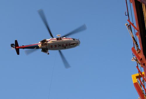 1月7日,交通運輸部北海救助飛行隊救助直升機(jī)B-7313飛臨外籍集裝箱船上空,準(zhǔn)備施救。新華社 發(fā)