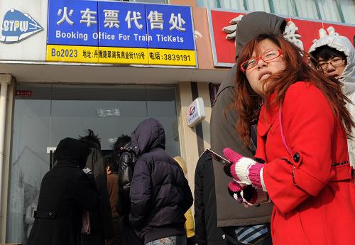 1月9日,在合肥市大學城一處火車票代售點,幾名大學生在排隊等待購買火車票。當日,合肥火車站開始預售春運首日的火車票,旅客可以通過火車站售票窗口、市內各火車票代售點以及撥打95105105等多種方式購買火車票。據悉,為了方便大學生購買票,在校大學生憑學生證可在合肥市27個火車票代售點,41個代售窗口就近購買火車票,無需支付5元手續(xù)費。新華社記者 劉軍喜 攝
