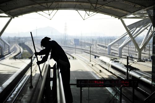 12月31日,在廣珠城際鐵路始發(fā)站廣州南站,CRH1A-250型和諧號(hào)動(dòng)車組靜待出發(fā),一位保潔員正在擦洗扶手玻璃。當(dāng)日,廣珠城際鐵路開(kāi)始試運(yùn)行,列車最高時(shí)速達(dá)250公里,連通廣州市、佛山市、江門市、中山市、珠海市等城市,開(kāi)通以后從廣州市到珠海市僅需40分鐘左右。新華社記者 梁旭 攝