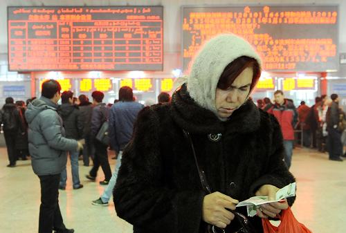 1月10日,一位旅客在烏魯木齊火車南站售票大廳查看剛剛買到的火車票。當日,新疆烏魯木齊火車南站開始提前發(fā)售2011年春運首日(1月19日)各次列車車票。由于出疆火車票需求較大,截至當日13時,春運首日的出疆火車票已全部售完。新華社記者 王菲 攝