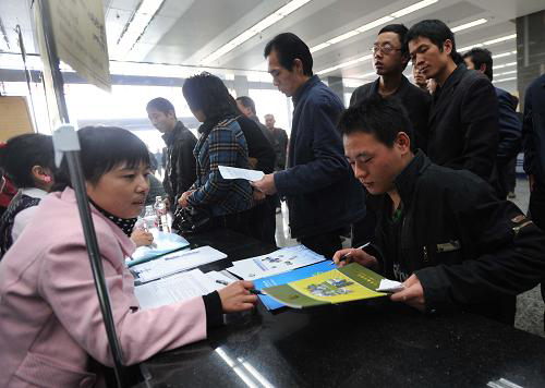 12月19日,一家用人單位工作人員(左)正在向求職者介紹職位信息。新華社記者 李尕?cái)z