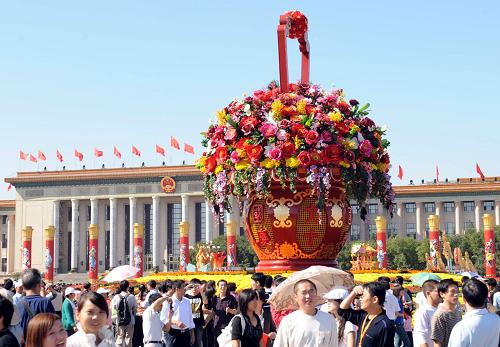10月2日,游客在天安門廣場中心的“普天同慶”巨型花壇前參觀。