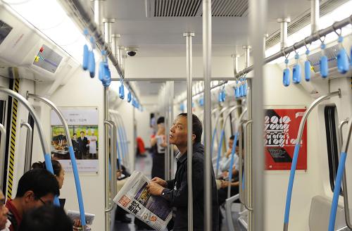 9月27日,一位市民在首趟試運營的地鐵列車里查看列車運行情況。經(jīng)過4年多的緊張施工及運營籌備,成都地鐵1號線一期工程于當日正式開通試運營。這是我國西部地區(qū)開通的首條地鐵線路。成都地鐵1號線一期工程線路為南北方向,貫穿成都市主城區(qū),全長18.5公里,共設(shè)17座車站,工程投資約80億元。新華社記者 江宏景攝