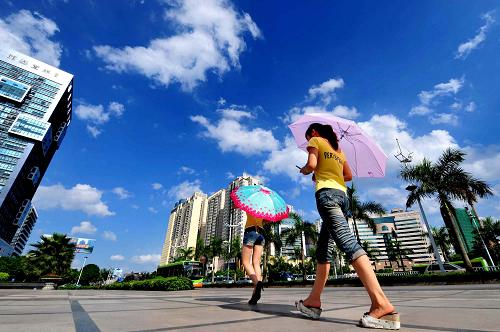7月4日,兩名女孩走過藍(lán)天白云下的廣西南寧市街頭。新華社記者黃孝邦攝