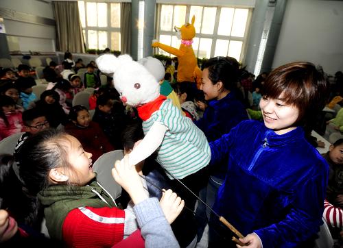12月21日,沈陽市望湖路小學(xué)的學(xué)生和木偶戲表演者進(jìn)行互動(dòng)。新華社發(fā)(張文魁 攝)