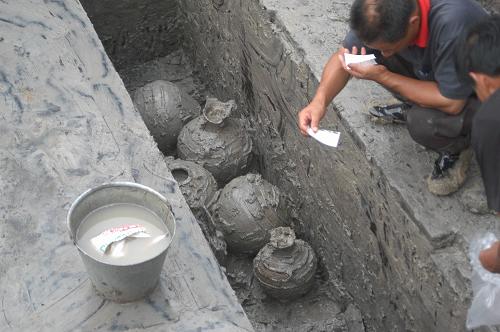 7月29日,考古人員在揚(yáng)州市維揚(yáng)區(qū)西湖鎮(zhèn)漢代墓葬挖掘現(xiàn)場(chǎng),清理出土的陶罐等陪葬品。新華社發(fā)(王乃駟 攝)