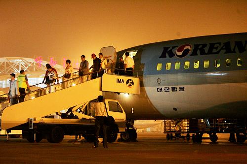 7月30日晚,在內(nèi)蒙古呼和浩特機(jī)場,韓國游客走下旅游包機(jī)的舷梯。新華社記者 鄭煥松 攝