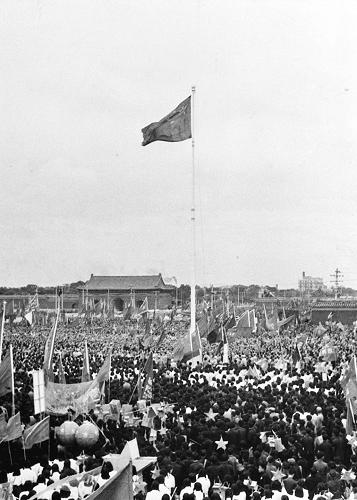 圖為1949年10月1日,毛澤東主席按動電鈕,新中國第一面五星紅旗冉冉升起。新華社發(fā)(資料照片)