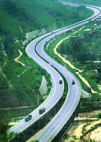 通過延安的包茂高速公路被綠色包圍(2009年7月29日攝)。 60年跨越,60年輝煌。一條條土路變成高速公路,逐漸成網(wǎng);一條條高速鐵路在城市間架起,縮短著時空距離;一條條國內(nèi)、國際航線散射到世界各個角落;一艘艘中國巨輪遨游在四大洋,貨物通達五洲……60年的交通建設,不斷鋪就著大國騰飛之路。新華社發(fā)