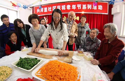 10月22日,大學(xué)生和社區(qū)志愿者為老人搟制長(zhǎng)壽面。 新華社發(fā)(李想 攝)