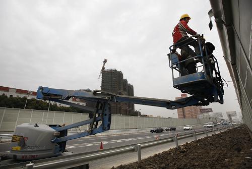 12月29日,工人正在即將通車的高速公路旁施工。 新華社記者 裴鑫 攝
