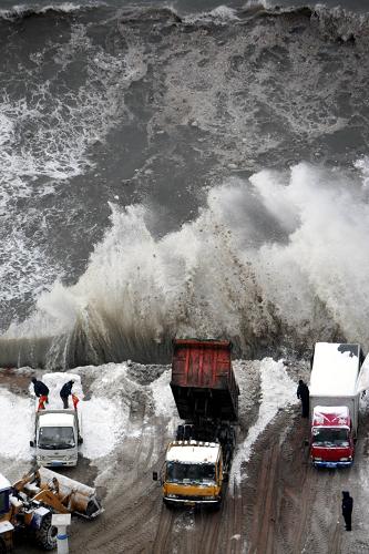 1月4日,清雪車(chē)在煙臺(tái)山下向大海里傾倒積雪。新華社發(fā)(柴向陽(yáng) 攝)