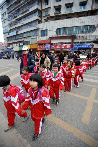 1月7日,貴陽市小河區(qū)的“綠絲帶”志愿者在引導(dǎo)小河區(qū)第一實驗學(xué)校的學(xué)生過馬路。 新華社記者 歐東衢 攝