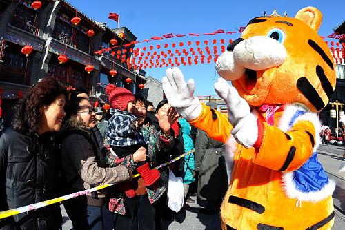 1月31日,“老虎玩偶”在前門步行街與游客互動(dòng)。新華社記者 羅曉光 攝