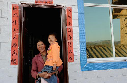 2月2日,云南省姚安縣官屯鄉(xiāng)官屯村的村民代菊萍抱著小孫女站在剛?cè)胱〉男戮娱T(mén)口。2009年7月9日,云南省楚雄彝族自治州姚安縣官屯鄉(xiāng)發(fā)生6.0級(jí)地震,造成數(shù)十萬(wàn)群眾受災(zāi),大批民房倒塌。春節(jié)臨近,姚安地震災(zāi)區(qū)的恢復(fù)重建工作正在加緊進(jìn)行,一些受災(zāi)群眾已經(jīng)搬入新居。新華社記者 藺以光 攝