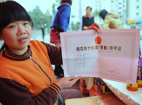 2月6日,經(jīng)營(yíng)者在福州市一煙花爆竹露天銷(xiāo)售點(diǎn)出示經(jīng)營(yíng)許可證。新華社記者 張國(guó)俊 攝