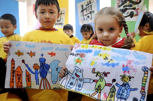 3月30日,江蘇連云港市鐘聲幼教機構久和幼兒園的中外小朋友在展示他們創(chuàng)作的世博主題圖畫。 當日,連云港市鐘聲幼教機構久和幼兒園的小朋友在課堂上用畫筆、彩色橡皮泥等創(chuàng)作世博主題繪畫,展示他們心目中的上海世博會景象。 新華社發(fā)
