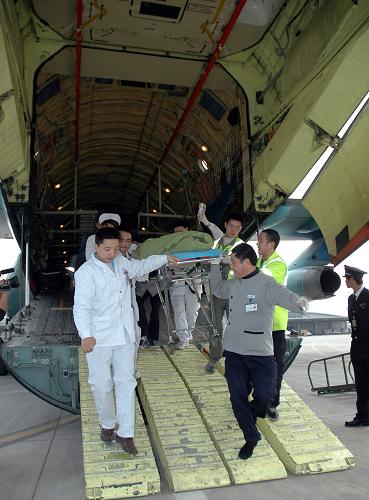 4月15日,來自青海玉樹地震災區(qū)的傷員抵達成都雙流機場后被護送下飛機。新華社發(fā)(宮軼韜 攝)