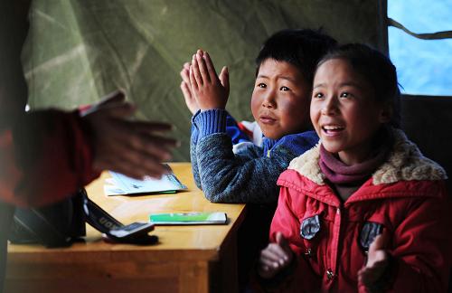 4月20日,在玉樹縣第二完全小學(xué),兩名兒童在聽志愿者為他們進(jìn)行心理輔導(dǎo)。新華社記者 聶建江 攝