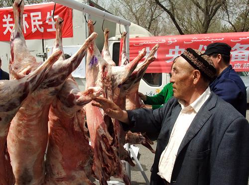 5月1日,一位烏魯木齊市民在購買投放市場的中央儲備羊肉。當(dāng)日,為平抑羊肉價格,保障群眾需求,新疆開始在烏魯木齊、和田等地市場投放中央儲備羊肉。據(jù)介紹,此次投放的中央儲備羊肉每公斤31元,低于一些地方的羊肉批發(fā)價。去冬今春以來,新疆主要牧業(yè)產(chǎn)區(qū)相繼遭受罕見的暴雪和低溫災(zāi)害,畜牧業(yè)正常生產(chǎn)受到嚴重影響。加上近期養(yǎng)殖成本提高等原因,新疆羊肉價格一直處于高位運行,影響到當(dāng)?shù)厝罕姷娜粘I睢P氯A社記者 周生斌 攝