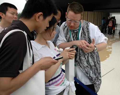 5月20日,芬蘭館的工作人員在核對游客領(lǐng)取的手機入場券。新華社發(fā)(李百順攝)