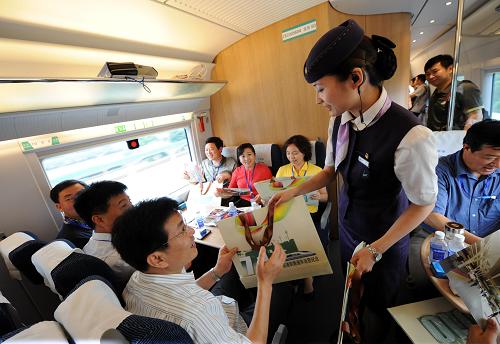 7月1日,滬寧城際線G5001次列車的列車員在向旅客贈送滬寧高速鐵路開通運營紀念郵品。新華社記者 孫參 攝